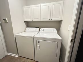 Lawrenceville house for rent - a laundry room with a washer and dryer and white cabinets
