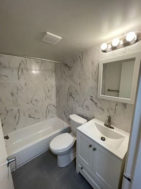 Ardmore apartment for rent - A white bathroom with a marble wall and a white toilet.