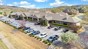 Bentonville apartment for rent - A parking lot in front of a building with cars parked.