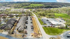 Bentonville apartment for rent - A suburban area with houses, a parking lot, and a road.