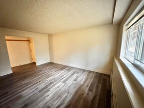Wasilla apartment for rent - A room with wooden flooring and a window on the right side.