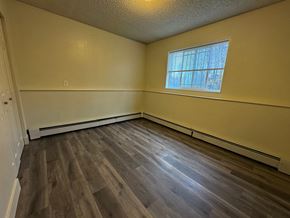Wasilla apartment for rent - A room with wooden flooring and a window with blinds.