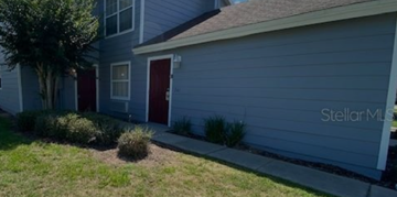 Davenport apartment for rent - A grey house with a red door and a tree in front.