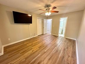 Clemson house for rent - A room with a ceiling fan and a flat screen TV mounted on the wall.