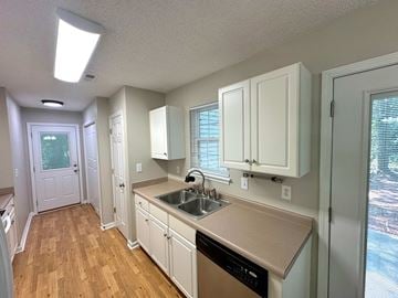 Clemson house for rent - A kitchen with white cabinets and a wooden floor.