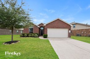 Katy house for rent - a brick house with a white garage door and a lawn