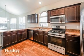 Katy house for rent - a kitchen with wooden cabinets and stainless steel appliances