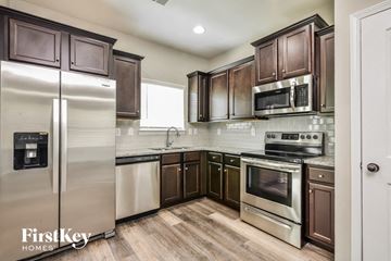 Lithonia house for rent - a kitchen with stainless steel appliances and wooden cabinets