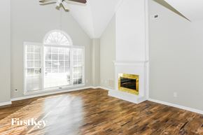 Concord house for rent - A spacious room with a fireplace and a ceiling fan.