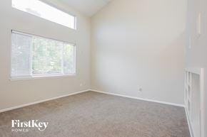 Brighton house for rent - a bedroom with a large window and a carpeted floor