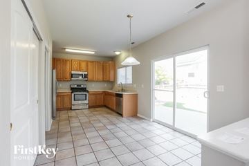 Brighton house for rent - a kitchen with wooden cabinets and a large glass door