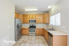 Brighton house for rent - a kitchen with wooden cabinets and stainless steel appliances