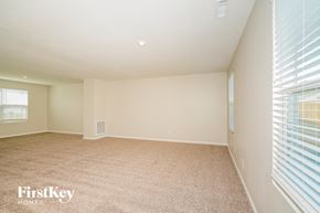 Greenwood house for rent - A spacious room with a carpeted floor and a window with blinds.