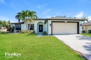 Cape Coral house for rent - A house with a garage and a palm tree in front.