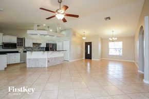 Cape Coral house for rent - A spacious kitchen and living room with a fan and tiled flooring.