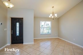 Cape Coral house for rent - A room with a black door and a chandelier.
