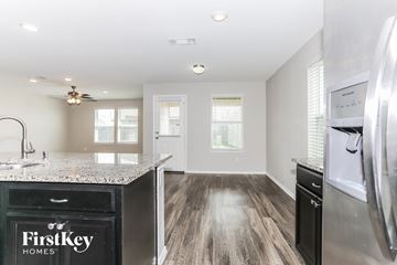 Hockley house for rent - a kitchen with granite counter tops and a stainless steel refrigerator