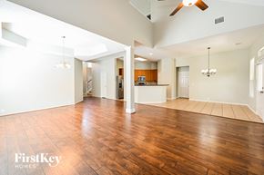 Houston house for rent - an empty living room with wood floors and a kitchen