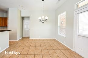 Houston house for rent - an empty dining room with a chandelier and a window