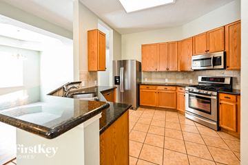 Houston house for rent - a kitchen with stainless steel appliances and wooden cabinets