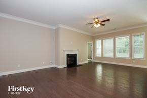 Denver house for rent - a living room with a fireplace and a ceiling fan