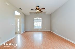 Lake Mary house for rent - an empty living room with wood floors and a ceiling fan
