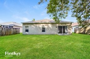 Lake Mary house for rent - a backyard with a small house and a yard with grass