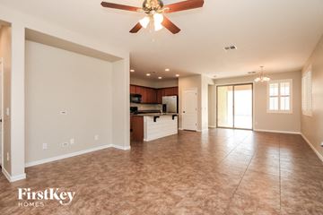 Gilbert house for rent - A spacious living room with a ceiling fan and lighting fixture.