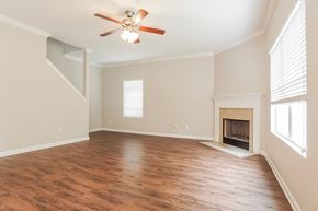 Calera house for rent - A room with a fireplace and a ceiling fan.