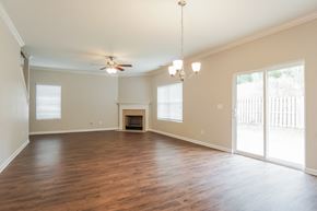 Calera house for rent - A spacious room with a fireplace and sliding glass doors.
