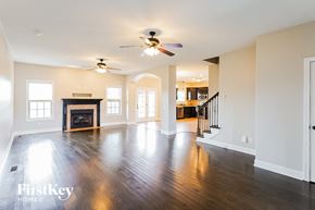 Clarksville house for rent - A spacious living room with a fireplace and a ceiling fan.
