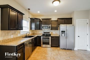 Clarksville house for rent - A kitchen with black cabinets and a FirstKey Homes logo.
