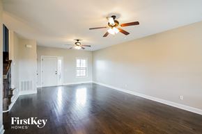 Clarksville house for rent - A spacious room with a ceiling fan and hardwood floors.