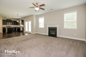 Powder Springs house for rent - an empty living room with a fireplace and a kitchen