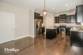 Powder Springs house for rent - a large kitchen with black cabinets and stainless steel appliances
