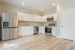 Jasper house for rent - a kitchen with white cabinets and stainless steel appliances