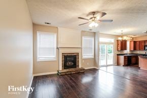 Canton house for rent - an empty living room with a fireplace and a ceiling fan