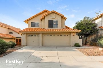 Tucson house for rent - a house with a garage and a driveway in front of it
