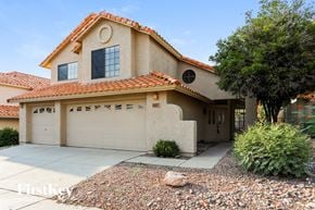 Tucson house for rent - a house with a garage door and a driveway