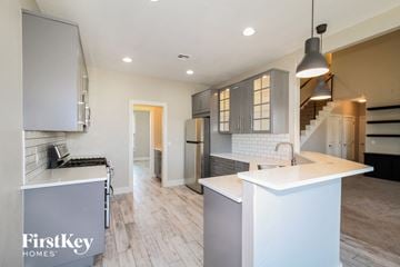 Yukon house for rent - a kitchen with white counter tops and a stainless steel refrigerator