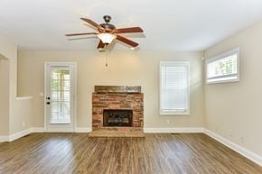 Clarksville house for rent - A room with a fireplace and a ceiling fan.