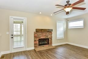 Clarksville house for rent - A room with a fireplace and a ceiling fan.