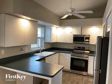 Venice house for rent - A kitchen with a black counter top and white cabinets.