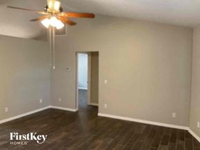 Venice house for rent - A room with a ceiling fan and wooden floors.