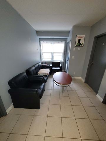 Waterloo apartment for rent - Living room with black couches and a round table.