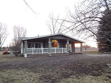 Rathdrum apartment for rent - a small white house with a porch and a tree