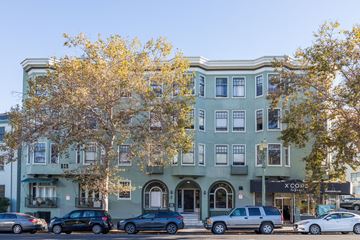 Oakland apartment for rent - A street view of a building with cars parked in front.