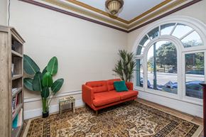 Oakland apartment for rent - A living room with a red couch, a potted plant, and a rug.