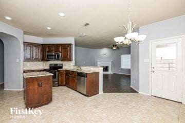 Fort Worth house for rent - a kitchen with wood cabinets and black appliances and a white door