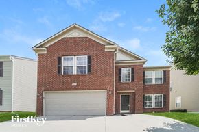 Charlotte house for rent - A brick house with a garage door is for sale.